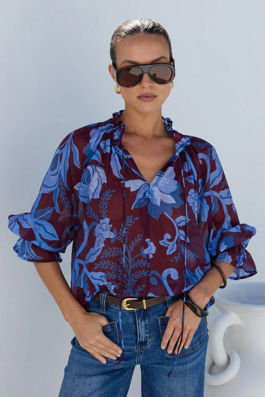 Image of a model wearing Tops. Product name - Expedition Burgundy Blue Floral Shirred Neck Short Sleeve Top in Burgundy Blue Floral colour by brand - Among the Brave