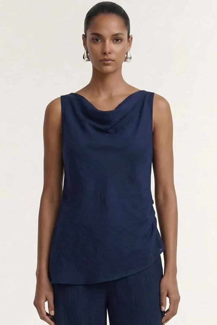 Image of a model wearing Tops. Product name - Helena Navy Cowl Sleeveless Top in Blue colour by brand - Staple The Label