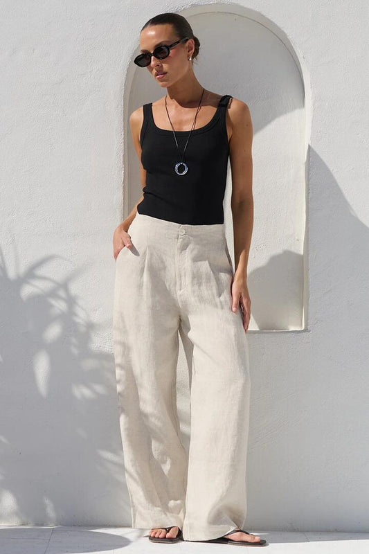 Image of a model wearing Pants. Product name - Curator Natural Linen Pleat Front Wide Leg Pants in Natural colour by brand - RE:UNION Label
