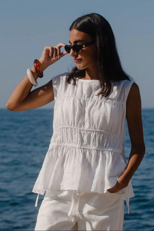 Image of a model wearing Tops. Product name - Context Ivory Linen Relaxed Sleeveless Top in Ivory Linen colour by brand - Stories be Told