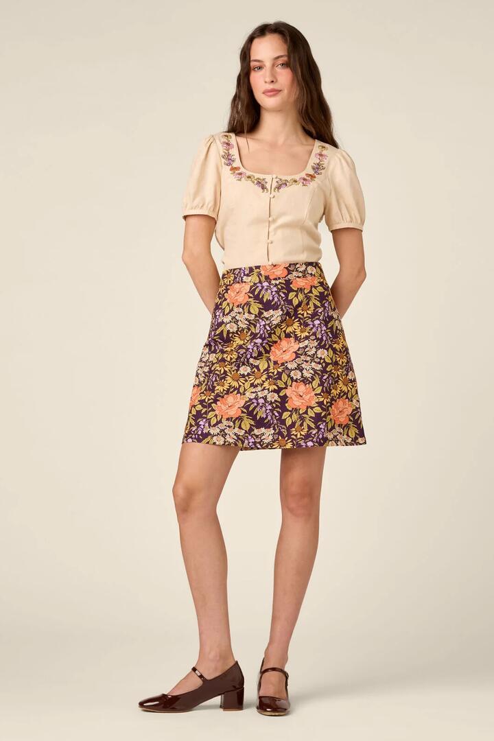 Image of a model wearing Skirts. Product name - Adelaide Floral Mini Skirt in Plum colour by brand - Princess Highway