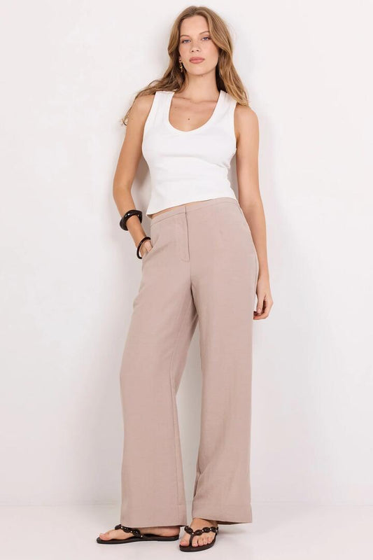 Image of a model wearing Pants. Product name - Charmed Stone Wide Leg Pants in Stone colour by brand - Stories be Told