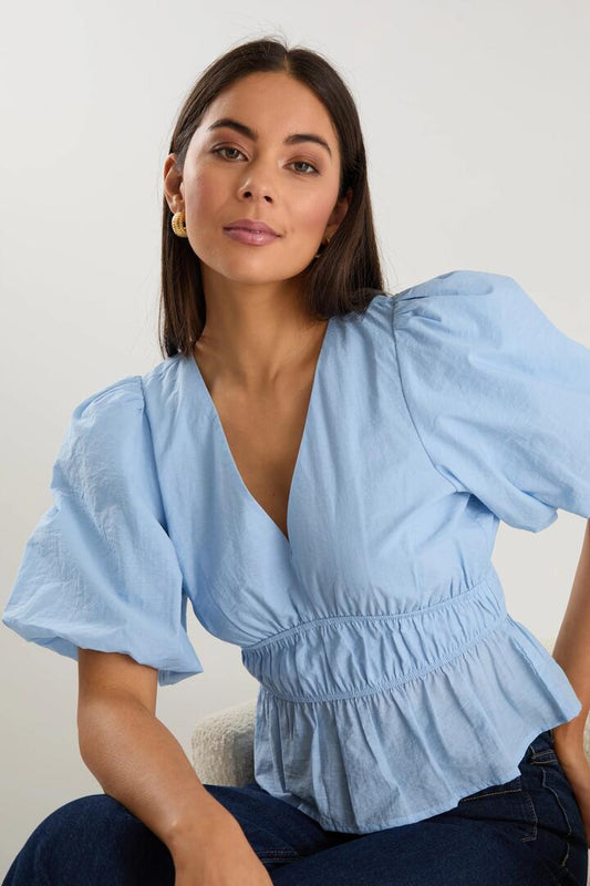 Image of a model wearing Tops. Product name - Vexing Ice Blue Puff Sleeve V Top in Ice Blue colour by brand - Georgia Zoe