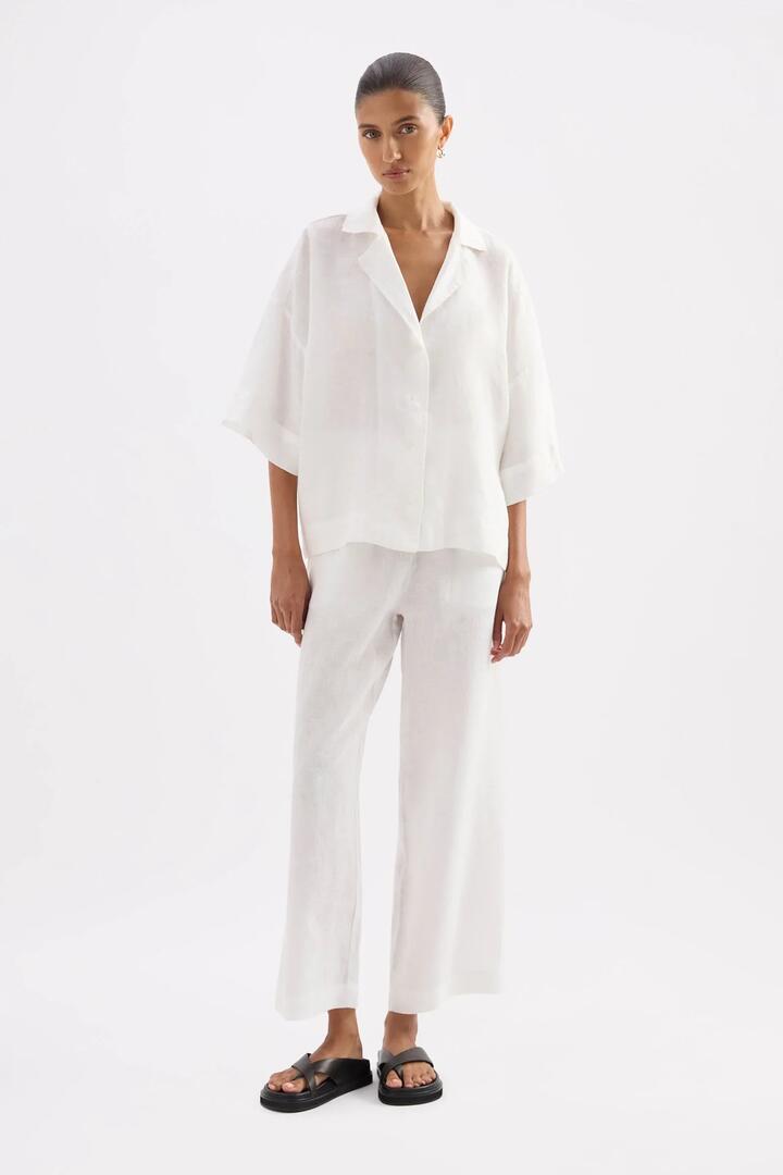Image of a model wearing Pants. Product name - Lounge White Linen Crop Pant in White colour by brand - Nude Lucy