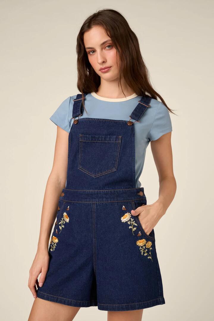 Image of a model wearing Pants. Product name - Strawflower Short Overall in Blue Denim colour by brand - Princess Highway