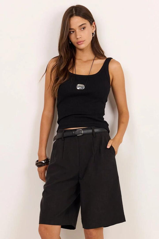 Image of a model wearing Shorts. Product name - Curated Black Tailored Bermuda Shorts in Black colour by brand - Among the Brave