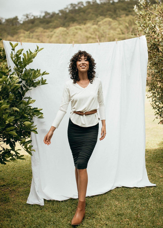 Image of a model wearing Skirts. Product name - Ross Ruched Bamboo Midi Tube Skirt Black in Black colour by brand - Lou Lou