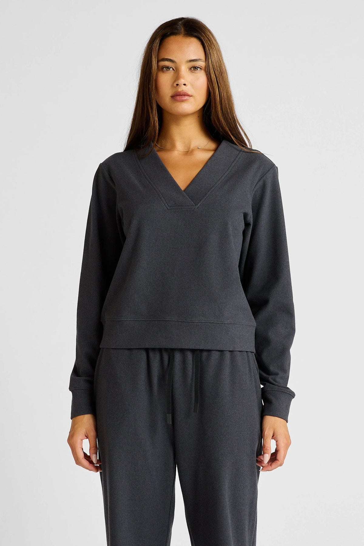 Image of a model wearing Outerwear. Product name - Micro-Rib V-Neck Cropped Sweater in Charcoal colour by brand - All Fenix