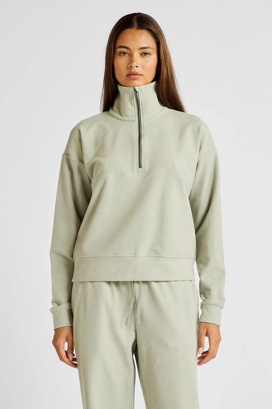 Image of a model wearing Outerwear. Product name - Micro-Rib 1/2 Zip Cropped Sweater in Seagrass colour by brand - All Fenix