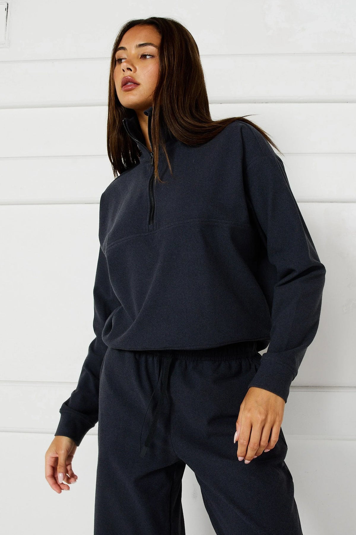 Image of a model wearing Outerwear. Product name - Micro-Rib 1/2 Zip Cropped Sweater in Charcoal colour by brand - All Fenix