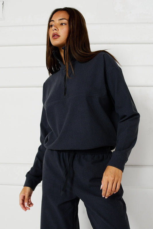 Image of a model wearing Outerwear. Product name - Micro-Rib 1/2 Zip Cropped Sweater in Charcoal colour by brand - All Fenix