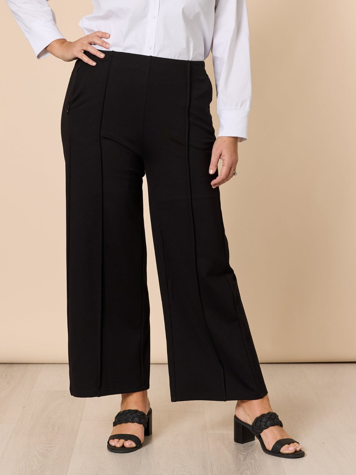 Image of a model wearing Pants. Product name - Miranda Pant Black in Black colour by brand - Hammock & Vine