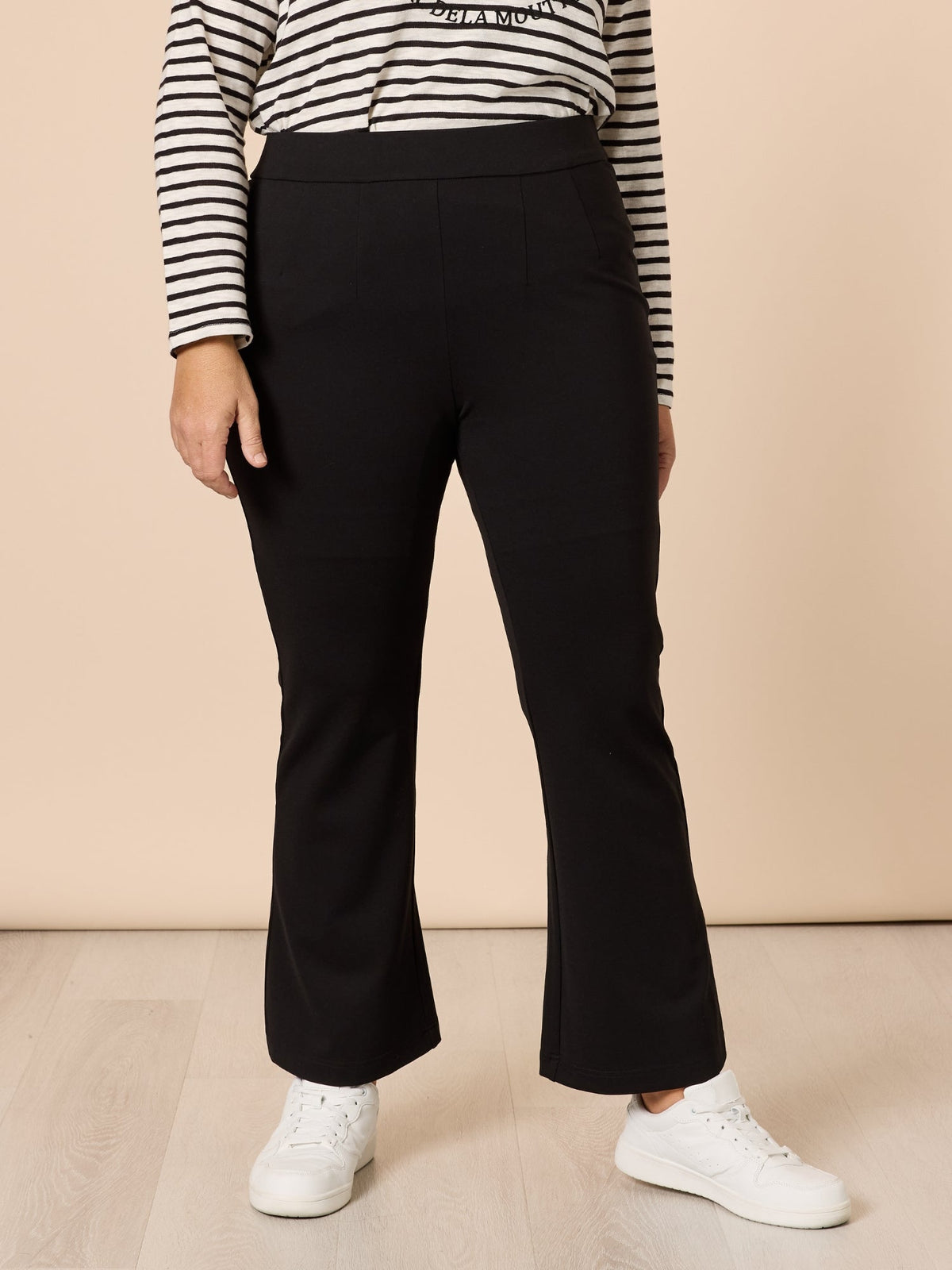 Image of a model wearing Pants. Product name - Carla Flare Pant Black in Black colour by brand - Threadz