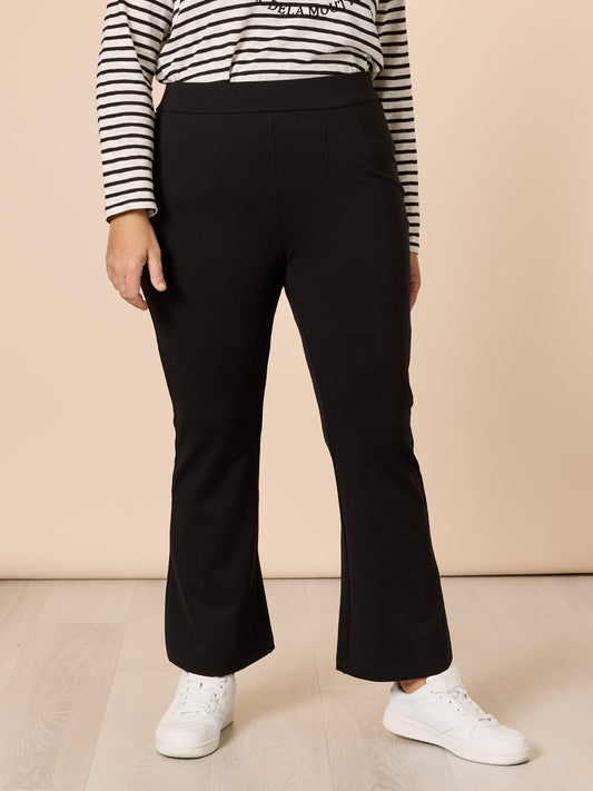 Image of a model wearing Pants. Product name - Carla Flare Pant Black in Black colour by brand - Threadz