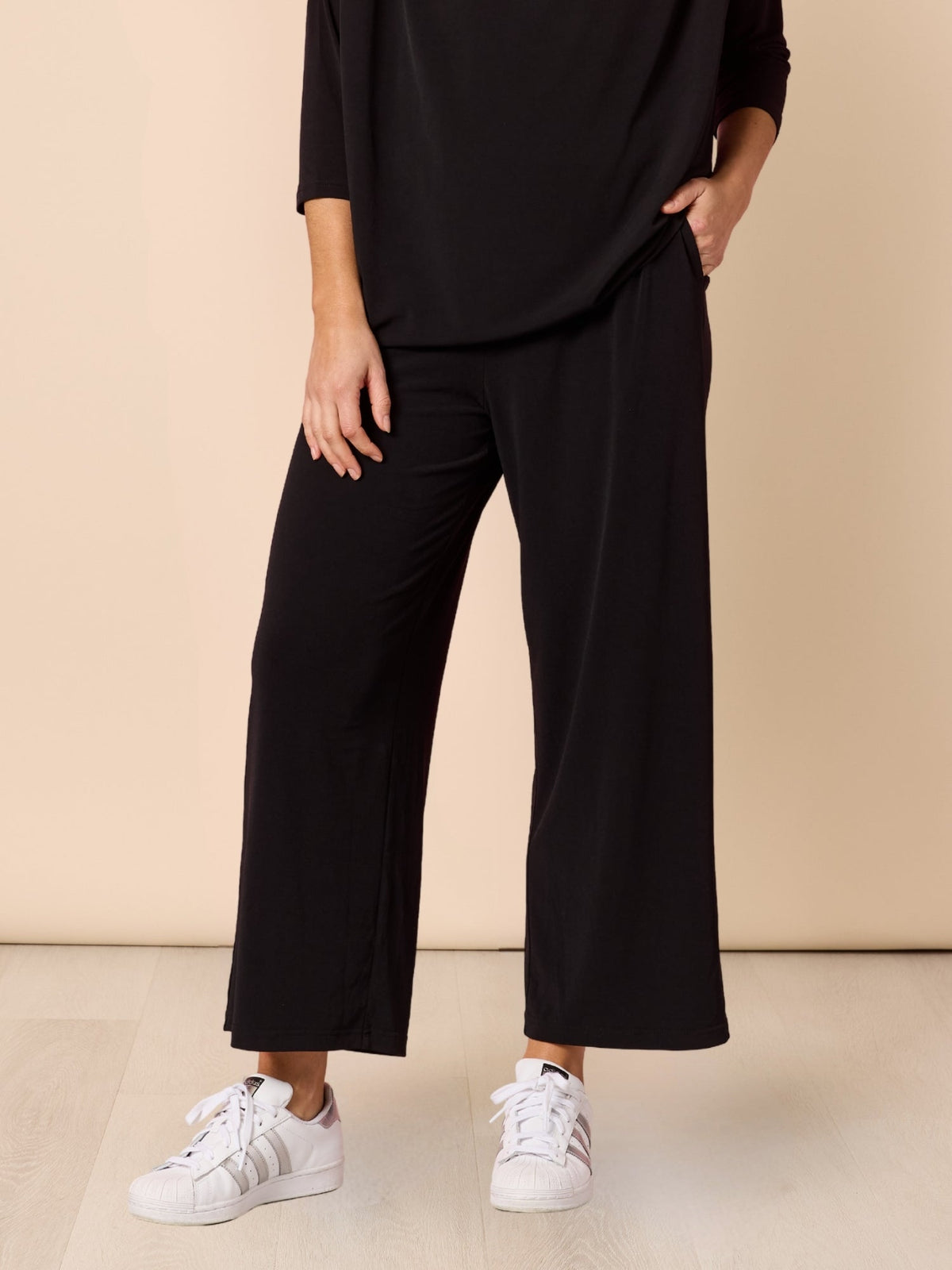 Image of a model wearing Pants. Product name - Traveller Wide Leg Pant Black in Black colour by brand - Clarity