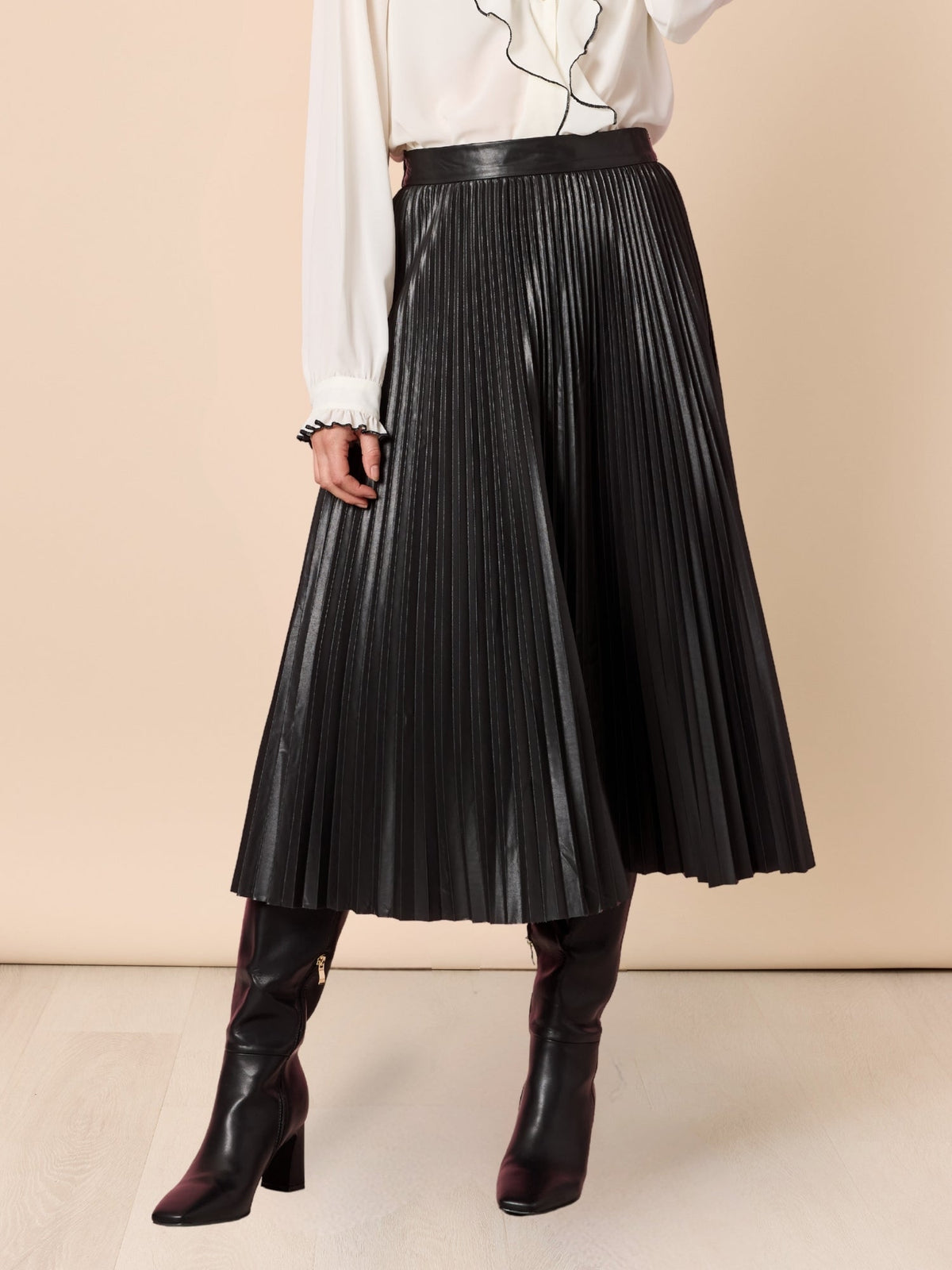 Image of a model wearing Skirts. Product name - Florence Pleat Skirt Black in Black colour by brand - Hammock & Vine