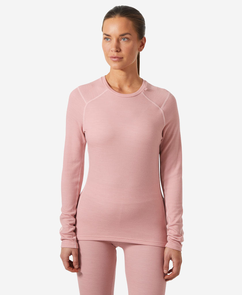 Image of a model wearing Tops. Product name - W LIFA MERINO MIDWEIGHT CREW, Pink Salt in Pink Salt colour by brand - Helly Hansen
