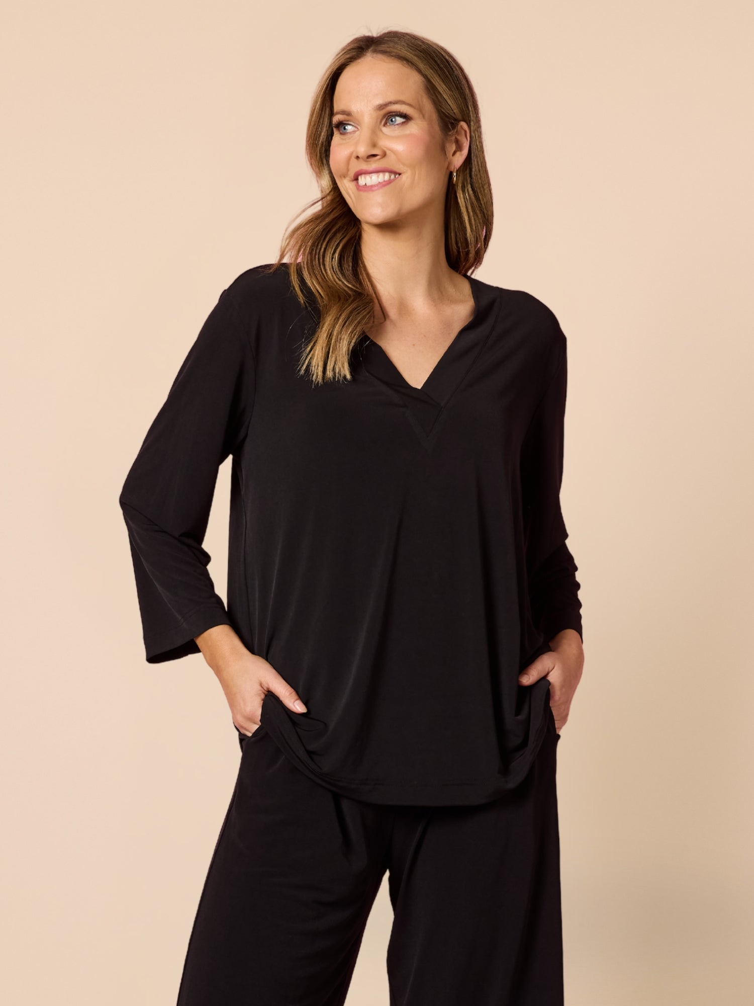 Image of a model wearing Tops. Product name - Traveller V Neck Top Black in Black colour by brand - Clarity
