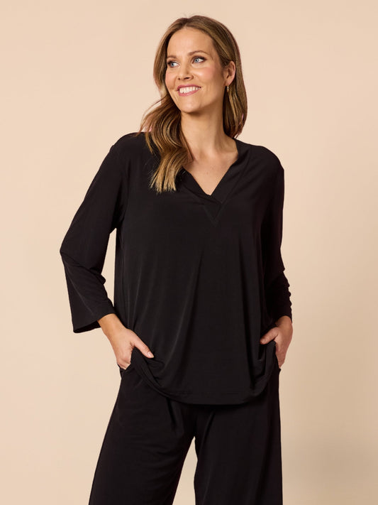 Image of a model wearing Tops. Product name - Traveller V Neck Top Black in Black colour by brand - Clarity
