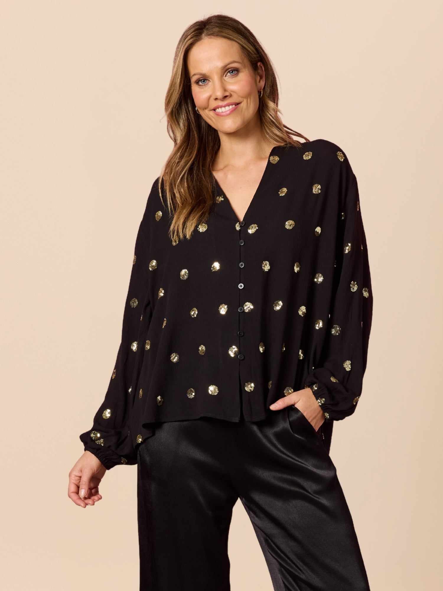 Image of a model wearing Tops. Product name - Allegra Sequin Spot Top Black in Black colour by brand - Hammock & Vine