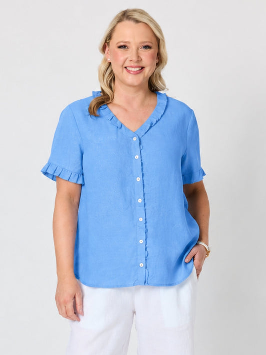 Image of a model wearing Tops. Product name - Audrey Linen Short Sleeve Ruffle Shirt Cornflower in Cornflower colour by brand - Gordon Smith