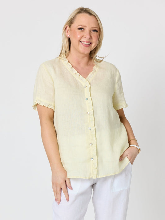 Image of a model wearing Tops. Product name - Audrey Linen Short Sleeve Ruffle Shirt Lemon in Lemon colour by brand - Gordon Smith