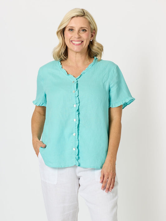Image of a model wearing Tops. Product name - Audrey Linen Short Sleeve Ruffle Shirt Seafoam in Seafoam colour by brand - Gordon Smith