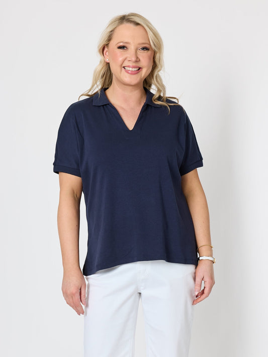Image of a model wearing Tops. Product name - Fairway Polo Top Navy in Navy colour by brand - Gordon Smith