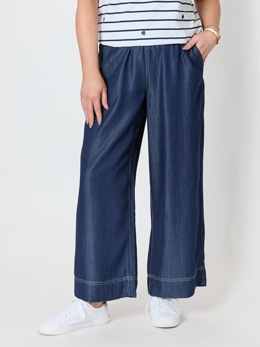 Image of a model wearing Pants. Product name - Monaco Wide Leg Denim Pant Denim in Denim colour by brand - Gordon Smith