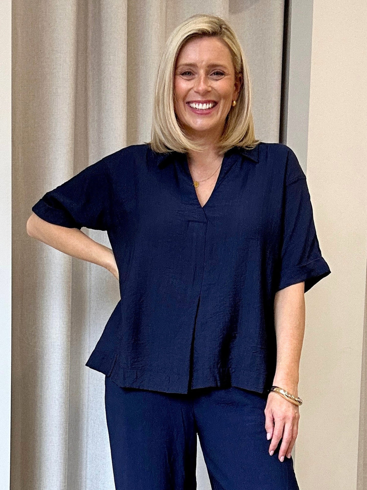 Image of a model wearing Tops. Product name - Del Mar Pleat Detail Top Navy in Navy colour by brand - Clarity
