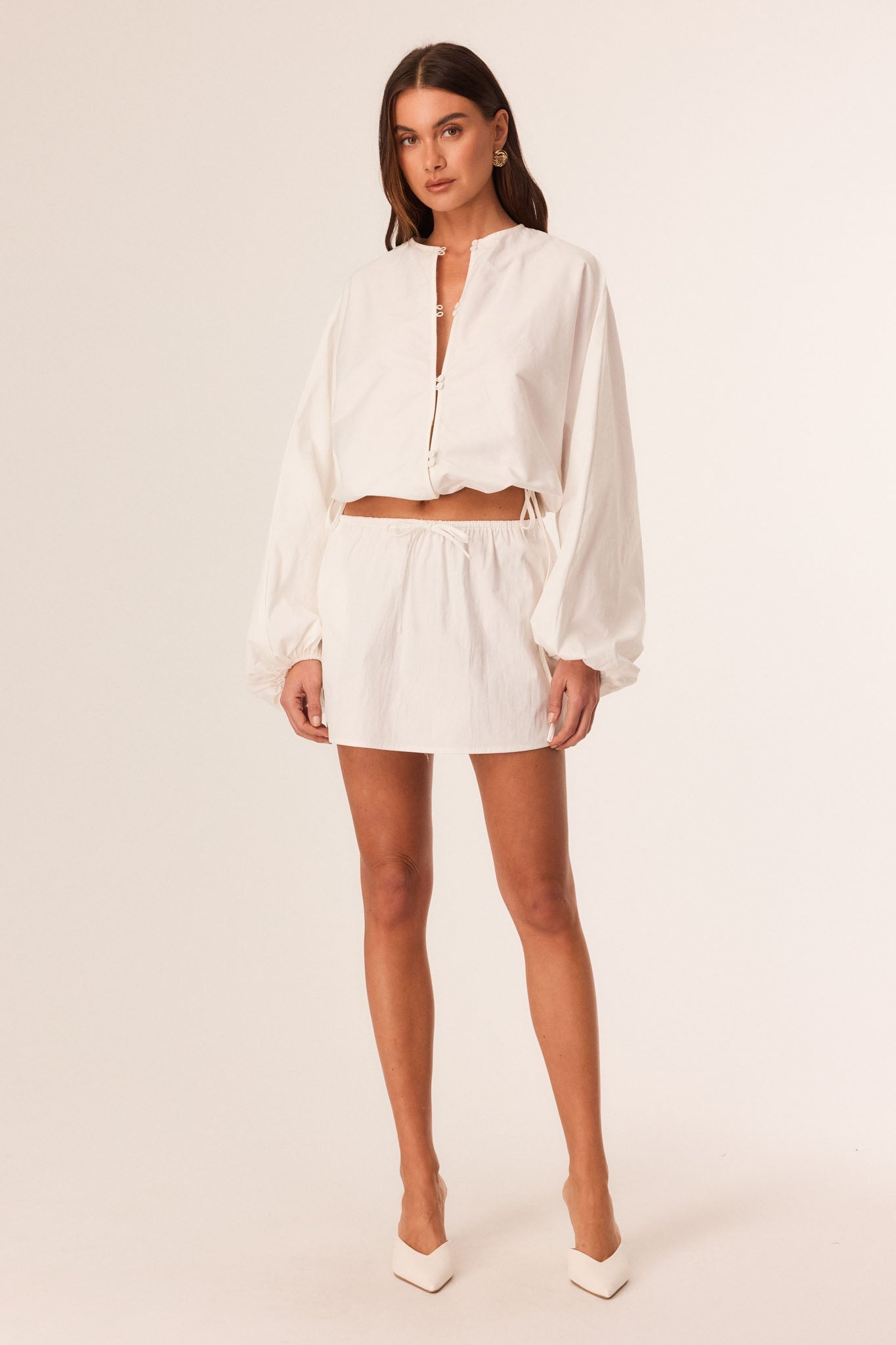Image of a model wearing Skirts. Productname: SNDYS EMMY MINI SKIRT in Off White colour by brand - SNDYS