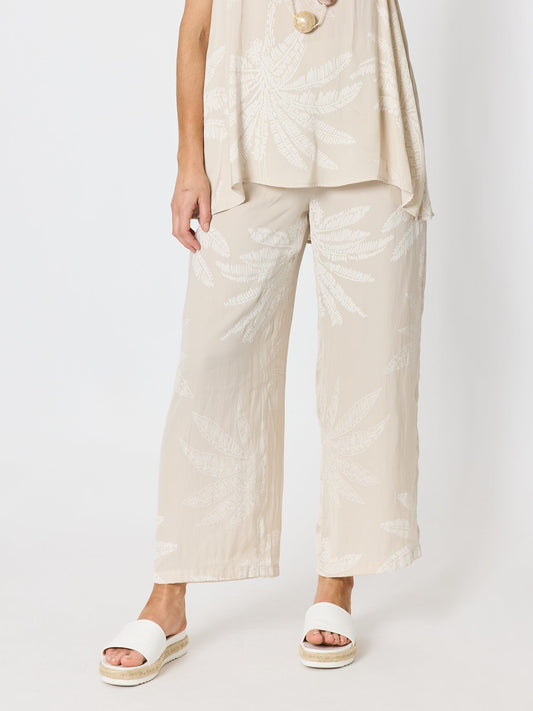 Image of a model wearing Pants. Product name - Sunset Palm Print Wide Leg Pant Natural/White in Natural/White colour by brand - Hammock & Vine