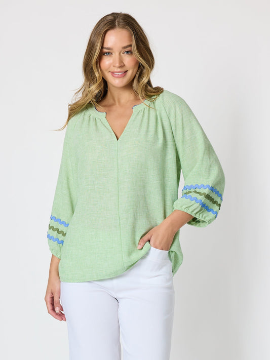 Image of a model wearing Tops. Product name - Canopy Ric Rac Top Apple in Apple colour by brand - Threadz