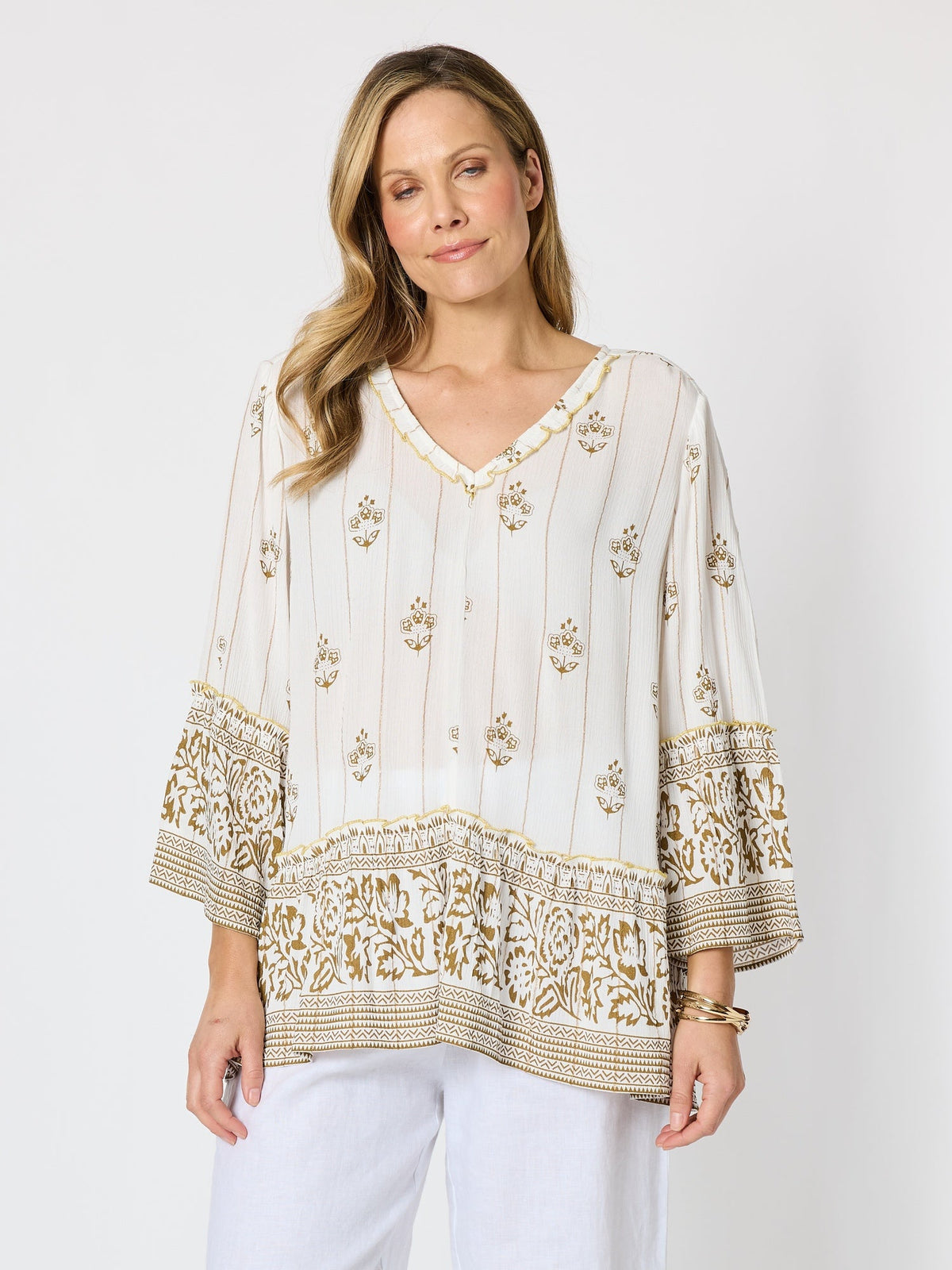 Image of a model wearing Tops. Product name - Sorrento Sunset Print Top Ivory Gold in Ivory Gold colour by brand - Hammock & Vine