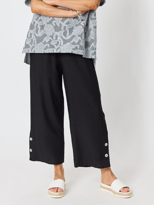 Image of a model wearing Pants. Product name - Essential Button Wide Leg Pant Black in Black colour by brand - Clarity