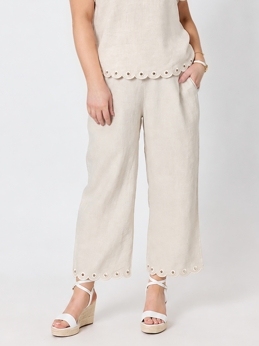 Image of a model wearing Pants. Product name - Lilly Scallop Hem Linen Pant Natural in Natural colour by brand - Gordon Smith