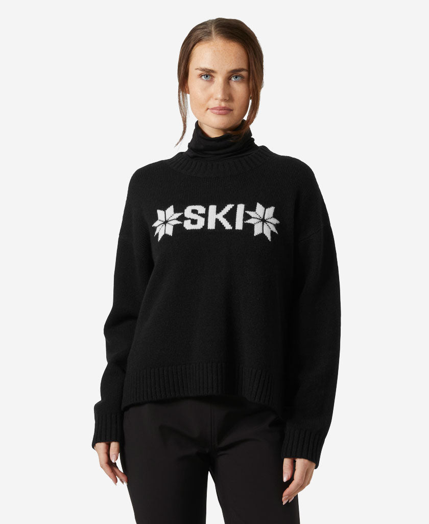 Image of a model wearing Outerwear. Product name - W BLISS SKI KNIT SWEATER, Black in Black colour by brand - Helly Hansen