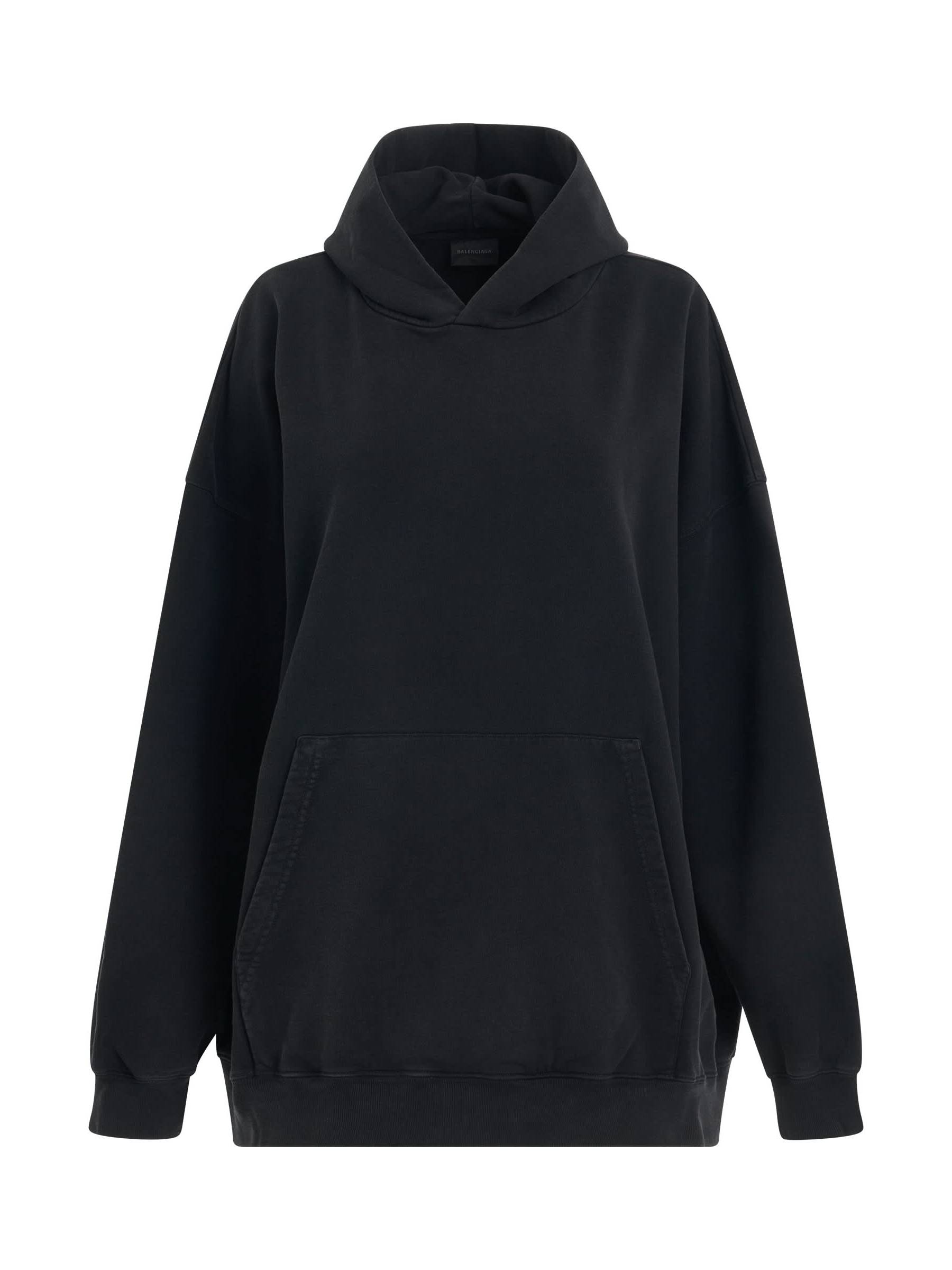 Image of a model wearing Outerwear. Productname: BALENCIAGA Back Logo Oversized Hoodie in Black Silver colour by brand - BALENCIAGA