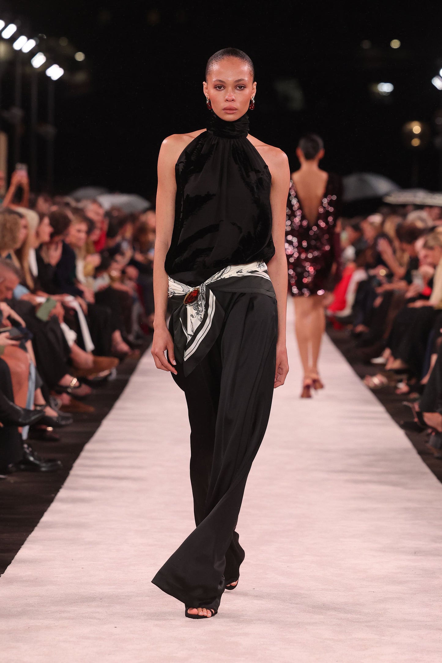 Image of a model wearing Tops. Product name - Black Velvet Burnout Halter Top in Black colour by brand - Carla Zampatti