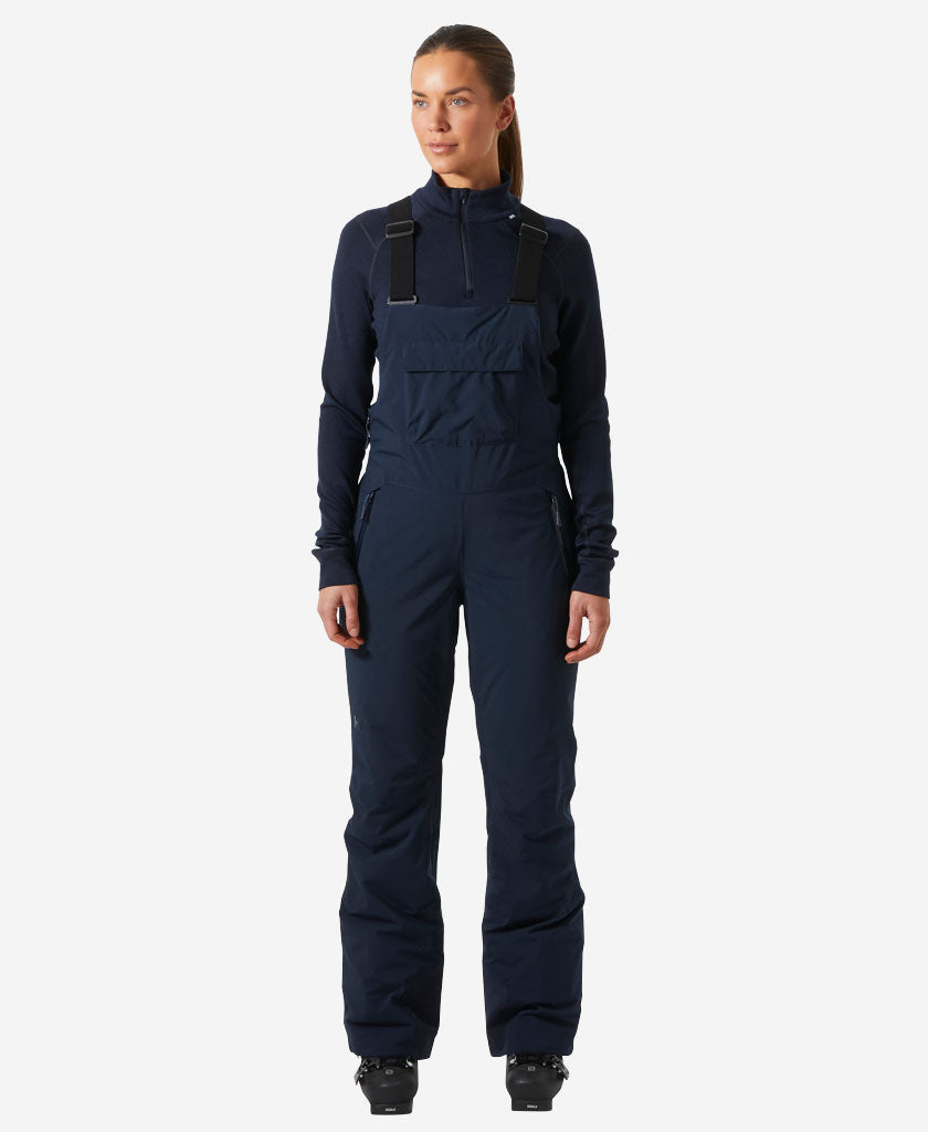 Image of a model wearing Pants. Product name - W LEGENDARY INSULATED BIB PANT, Navy in Navy colour by brand - Helly Hansen