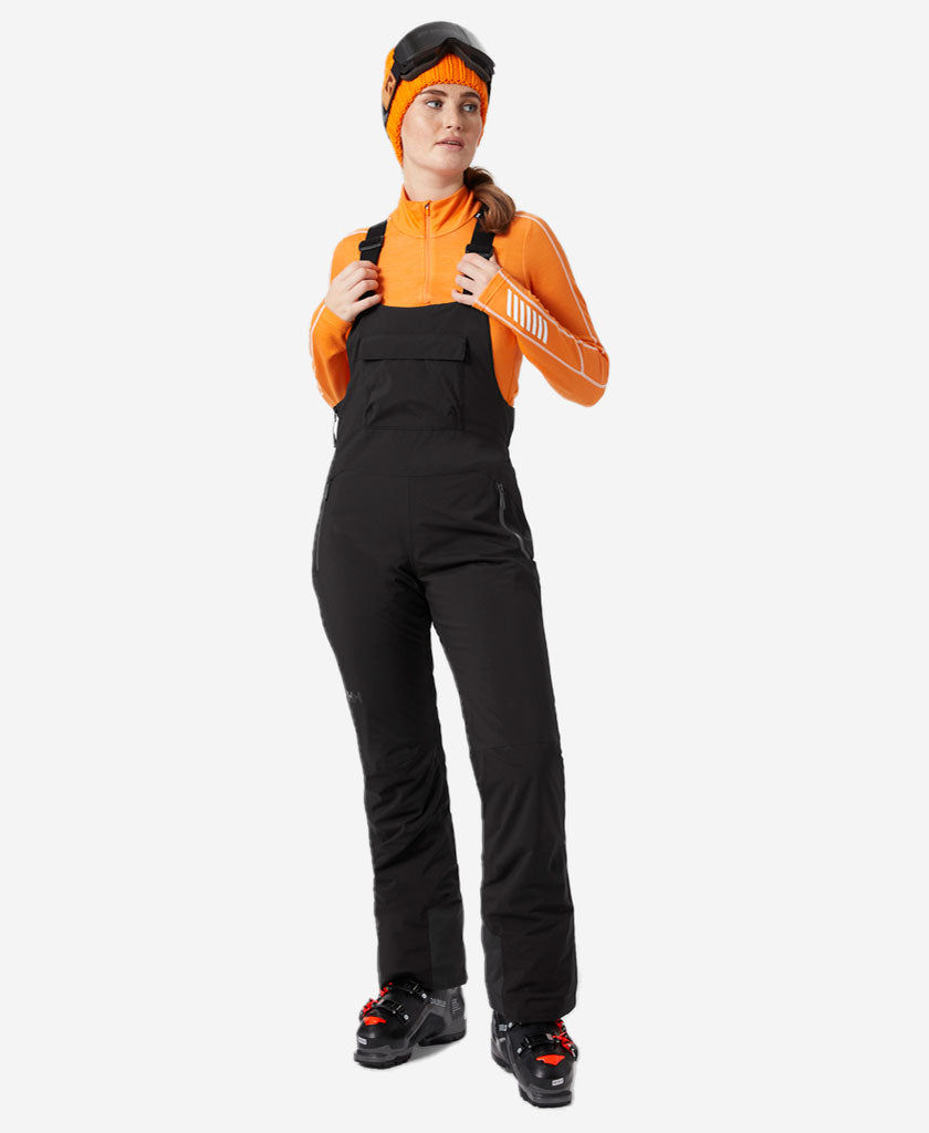 Image of a model wearing Pants. Product name - W LEGENDARY INSULATED BIB PANT, Black in Black colour by brand - Helly Hansen