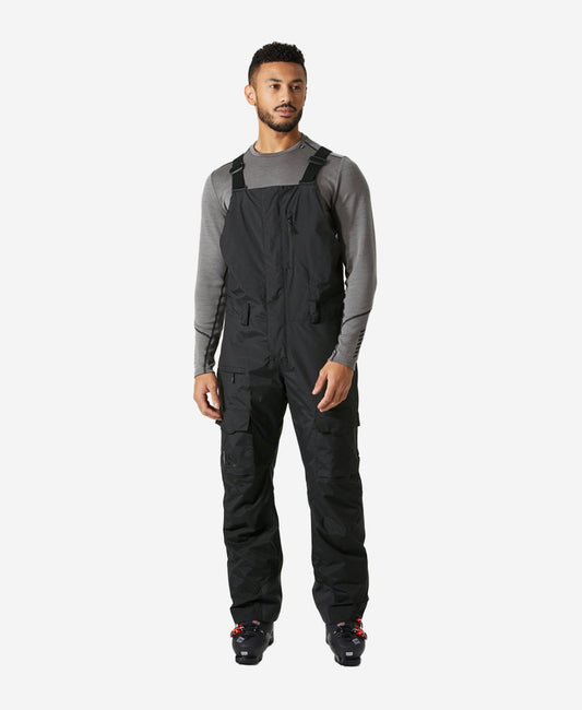 Image of a model wearing Pants. Product name - SOGN BIB CARGO PANT, Black in Black colour by brand - Helly Hansen