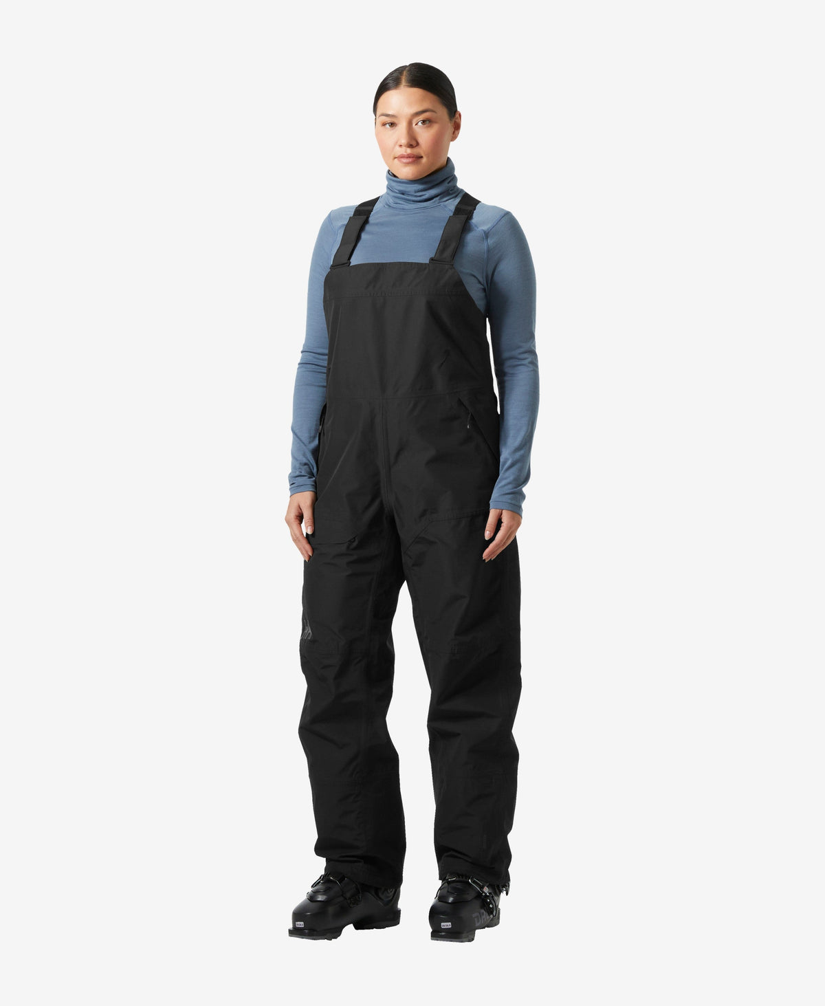 Image of a model wearing Pants. Product name - W EMIKO SHELL BIB PANT, Black in Black colour by brand - Helly Hansen