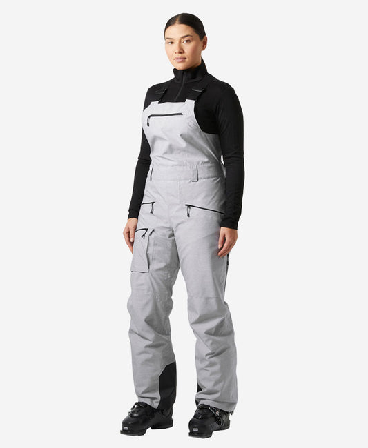 Image of a model wearing Pants. Product name - W POWDERQUEEN BIB 2.0 PANT, Grey Melange in Grey Melange colour by brand - Helly Hansen
