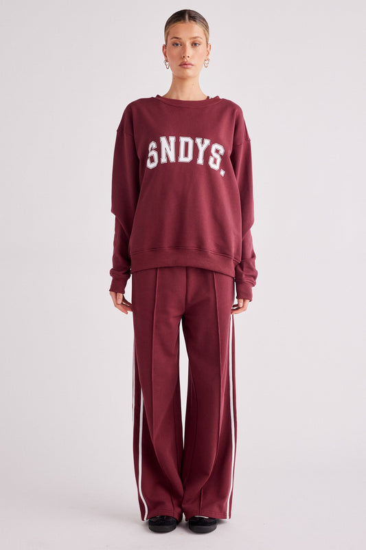 Image of a model wearing Outerwear. Productname: SNDYS Friday Varsity Jumper in Cherry colour by brand - SNDYS