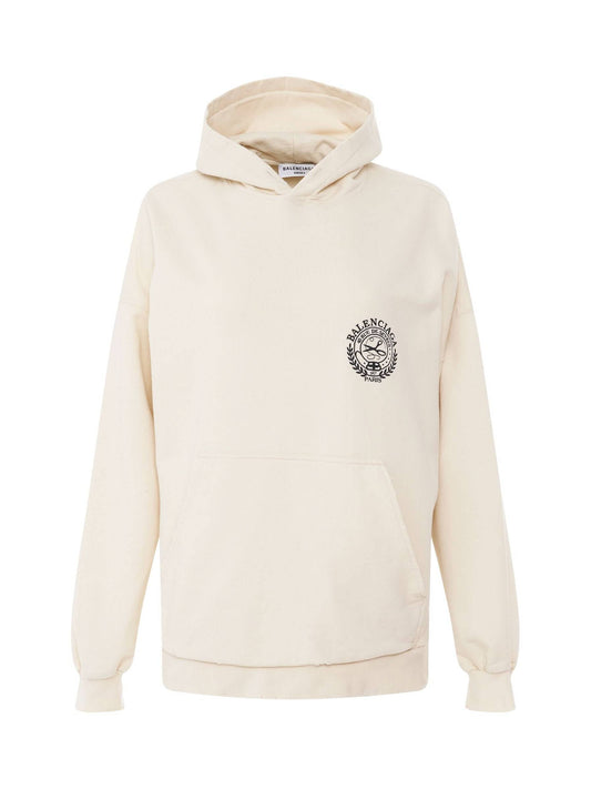 Image of a model wearing Outerwear. Productname: BALENCIAGA Scissors Crest Embroidered Wide Fit Hoodie in Cream colour by brand - BALENCIAGA