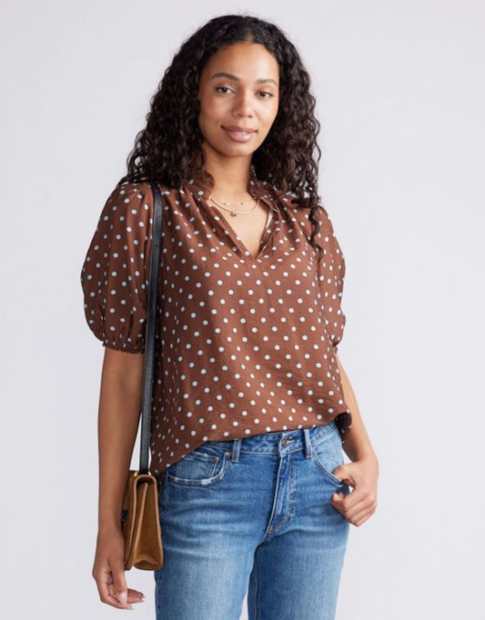 Image of a model wearing Tops. Product name - Ascot Ruffle Blouse Choc/Blue Polka Dot in Choc/Blue Polka Dot colour by brand - White & Co.