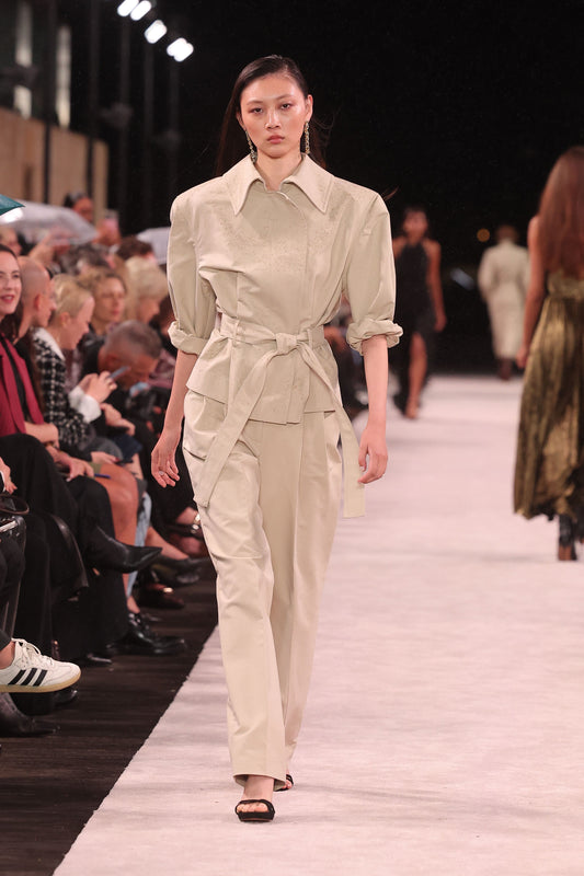 Image of a model wearing Shorts. Product name - Bone Luxe Cotton Drill Short Trench Coat in Cream colour by brand - Carla Zampatti