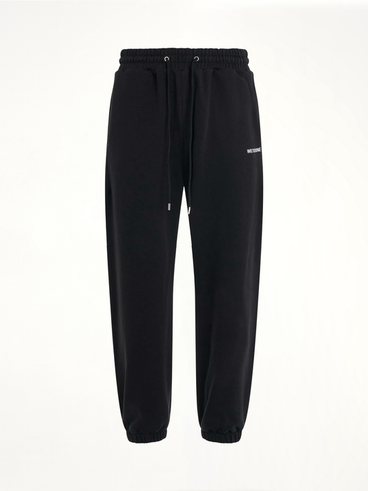 Image of a model wearing Pants. Productname: WE11DONE Logo Medium Lounge Pants in Black colour by brand - WE11DONE