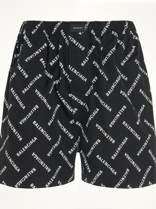 Image of a model wearing Shorts. Productname: BALENCIAGA All-Over Logo Pyjama Shorts in BLACK colour by brand - BALENCIAGA